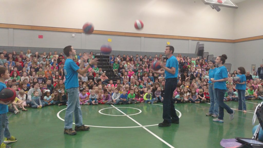 Juggling basketballs at a school gym event